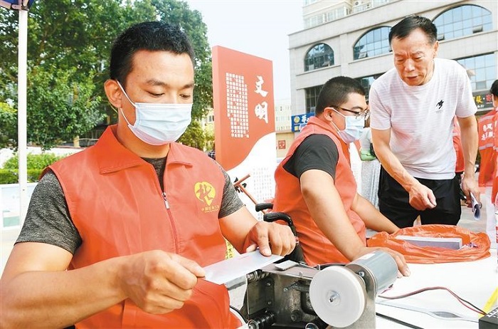 目前，全市组建区县志愿服务总队20支，实施志愿服务项目1173个。图为志愿者为居民提供磨刀服务。 （首席记者 李明 摄 资料图片 ）.jpg